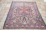 Antique Kerman rug's classic medallion and curvilinear florals in time-softened hues.
