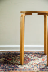 Upper curved light wood legs of a vintage Alvar Aalto style stool.