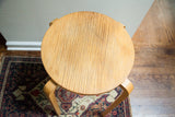 Vintage Alvar Aalto high stool top with prominent wood grain striations and surface wear.