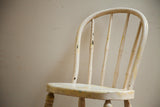 Chippy ivory and yellow paint on the antique child's chair backrest.