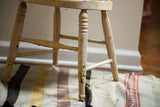 Chippy ivory white and yellow paint detail on antique child's Windsor chair legs.