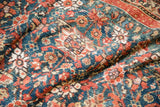 Allover pomegranate design on the natural green field of this antique Persian carpet.