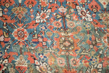 Intricate pomegranate design on a green-teal antique Persian carpet, showing rewoven restorations in softer tones.