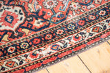Antique Persian Malayer border detail with madder red, navy, saffron, and cream floral motifs.
