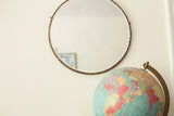 Ornate scalloped edge of an antique beveled glass mirror.
