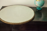 Antique beveled glass mirror with a textured, aged metallic scalloped edge.