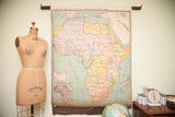 Antique Nystrom pulldown map of Africa with aged pastel colors and original roller.