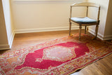 Vintage Turkish raspberry red runner rug with intricate lattice medallion and saffron silver motifs.