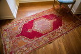 Intricate central medallion with lattice webbing on vintage Turkish raspberry red rug.