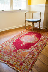 Intricate central medallion with lattice webbing on vintage raspberry red Turkish runner.