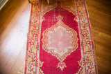 Raspberry red vintage Turkish runner with intricate lattice medallion and vine border.