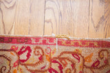 Vintage Turkish rug's hand-knotted raspberry red border and saffron yellow motifs.