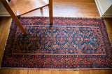 Intricate coral Herati pattern on the finely woven indigo field of this vintage Malayer.