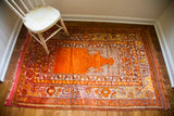 Orange Turkish prayer rug, showing mauve and silver prayer niche, with red and purple borders.