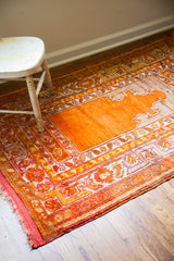 Vibrant orange vintage Turkish prayer rug corner with red plainweave and detailed floral border.