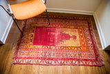 Worn red and gold border details with tattered fringe on the vintage Turkish prayer rug.