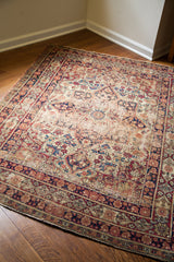 Decorative distressed texture on an antique Persian Kerman rug with classic medallion and rich blue tones.