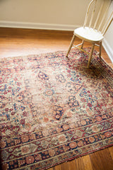 Antique Kerman rug's decorative distressed border with muted red and deep blue florals.