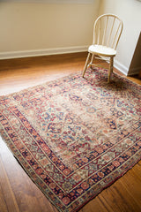 Antique Kerman rug with a decorative distressed aesthetic and faded blue-red patterns.