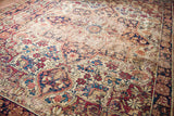 Distressed pile texture with muted red and blue floral motifs on the Kerman rug.