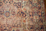 Distressed texture and exposed foundation of an antique Kerman rug with muted floral patterns.