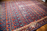 Tattered red and blue Caucasian rug edge with worn pile and repeating boteh design.