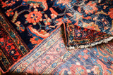 Antique Lilihan rug with worn indigo pile, whimsical coral motifs, and hand-knotted foundation.