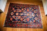 Intricate coral floral design and abrash-rich indigo ground of an antique Lilihan rug.