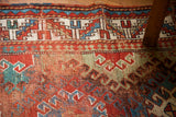 Worn colorful geometric design and border on a vintage Caucasian rug.