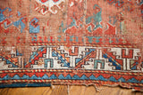 Vintage Caucasian rug shows colorful geometric border and aged, worn field texture.