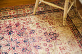 Worn antique Persian Kerman rug field, blanched ivory with cochineal red and navy motifs.