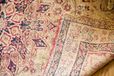Worn blanched antique Kerman pile with cochineal red scrolling pattern, revealing reverse border.