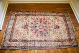 Powerful star-shaped medallion in cochineal red on blanched ivory antique Kerman rug.