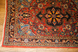 Finely woven vintage Persian Sarouk rug corner with intricate red, blue, and yellow patterns.