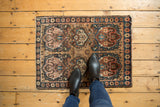 Antique Persian Farahan Sarouk mat displaying cloudband motif, rich earth tones, and blue abrash.