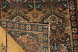 Folded antique Farahan Sarouk mat, showcasing hand-knotted pile, earth tone cloudbands, and detailed blue border.