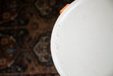 Curved ivory stool top with vintage chippy paint and scuff marks.