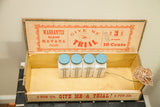 Antique Cuban cigar box interior, 'Give Me a Trial' graphics, four white bottles.