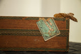 Aged 19th-century cigar box corner with torn blue-green tax stamp and decorative border.