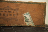 Antique cigar box side showing 'GIVE ME A TRIAL' graphics and torn vintage label.