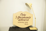 Vintage hand-painted shop sign on a yellow scalloped board with brown lettering.