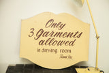 Hand-painted brown script on a vintage yellow sign with a semi-scalloped shape.