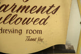 Angled view of the hand-painted brown script and aged patina on the yellow sign.