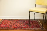 Saturated red field showcasing the intricate floral medallion and detailed border of the Sarouk rug.