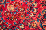 Vibrant ruby red pile with intricate sapphire blue and beige floral Sarouk rug motifs.