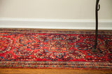 Vintage Red Sarouk rug's exceptional ruby red field, intricate blue and gold floral design.