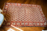 Distressed antique Persian Hamadan rug with ivory ground and unique rose border, circa 1915.