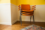 Stacked Pirelli by Castelli DSC chairs, showing rare orange textured fabric armrests.