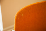 Vintage Pirelli chair's orange fabric detail, showing woven texture and light age marks.