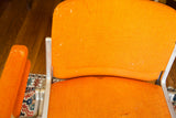 Pirelli Castelli DSC chair, textured orange fabric revealing visible wear and surface marks.